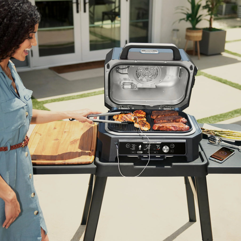 Ninja Woodfire Grill elektryczny, wędzarnia i frytkownica beztłuszczowa, 7 w 1, zewnętrzny, wędzenie, opiekanie, ciasta, odporny na pogodę, nieprzywierający, przenośny, szary/czarny OG701EU