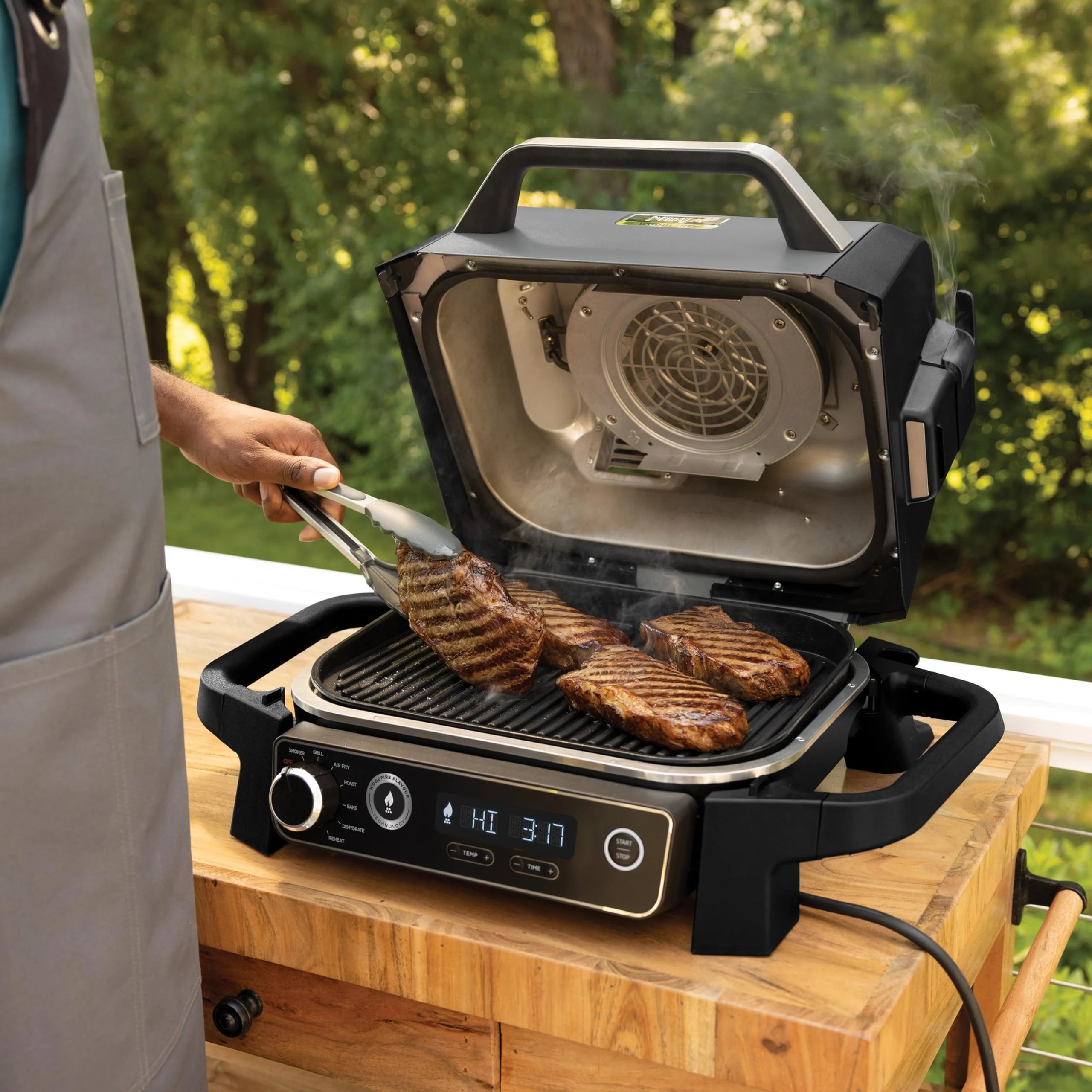 Ninja Woodfire Grill elektryczny, wędzarnia i frytkownica beztłuszczowa, 7 w 1, zewnętrzny, wędzenie, opiekanie, ciasta, odporny na pogodę, nieprzywierający, przenośny, szary/czarny OG701EU